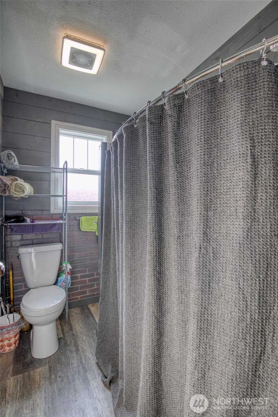 823 West 3rd Street Aberdeen, WA 98520 - Photo 14 of 40 a bathroom with a toilet and a shower curtain