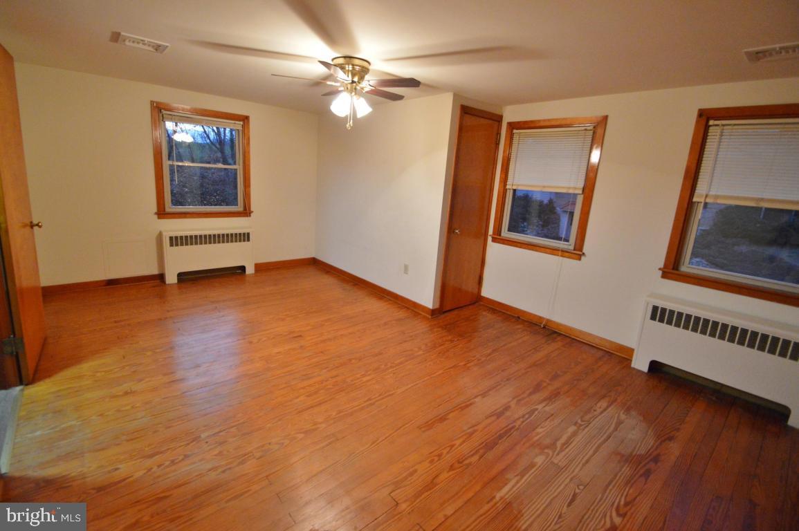 9 Hossler Road Manheim, PA 17545 - Photo 16 of 19 an empty room with wooden floor chandelier fan and windows