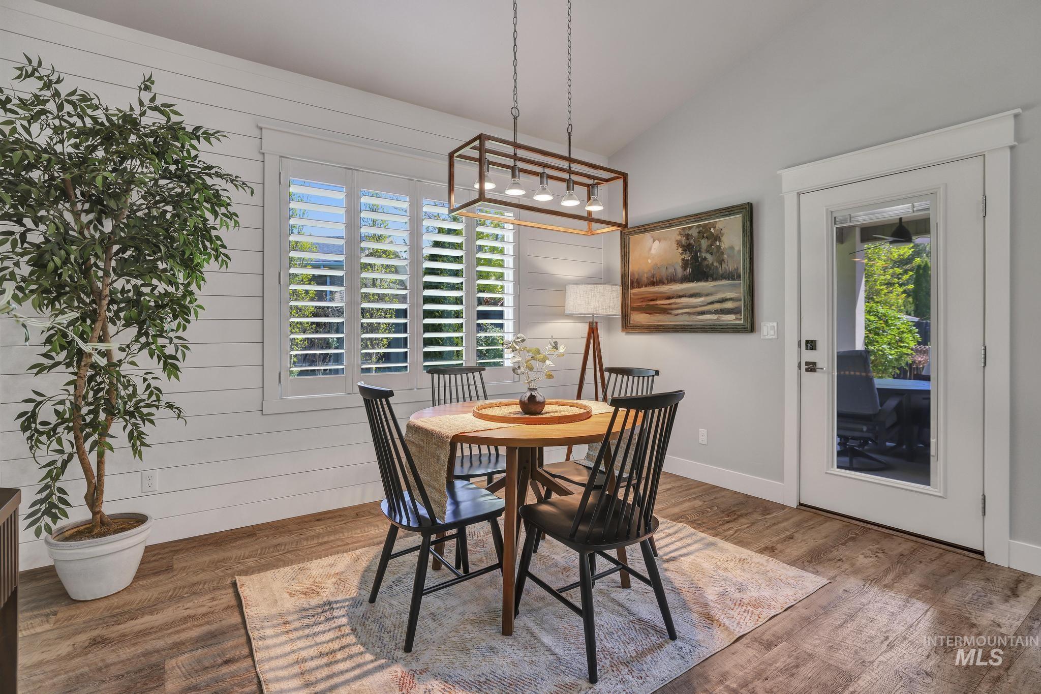 1937 Tamarack Loop Twin Falls, ID 83301 - Photo 21 of 50 Dining area with wood-finish flooring, shiplap accent wall, white window shutters, and a modern rectangular chandelier
