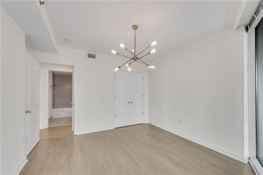 3338 Peachtree Road Northeast, Unit 1706 Atlanta, GA 30326 - Photo 17 of 37 wooden floor in an empty room with a window