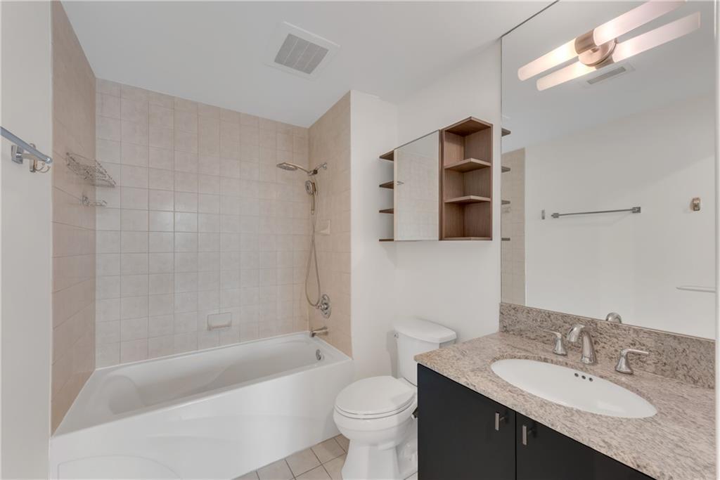 3338 Peachtree Road Northeast, Unit 1706 Atlanta, GA 30326 - Photo 18 of 37 a bathroom with a granite countertop sink toilet and shower