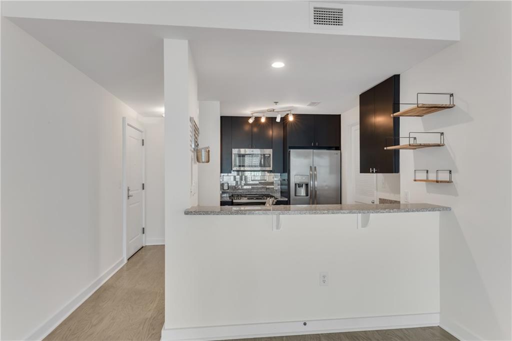 3338 Peachtree Road Northeast, Unit 1706 Atlanta, GA 30326 - Photo 3 of 37 a large white kitchen with kitchen island a sink and refrigerator