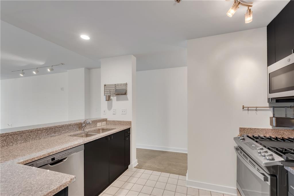 3338 Peachtree Road Northeast, Unit 1706 Atlanta, GA 30326 - Photo 7 of 37 a kitchen with granite countertop a sink stove and refrigerator