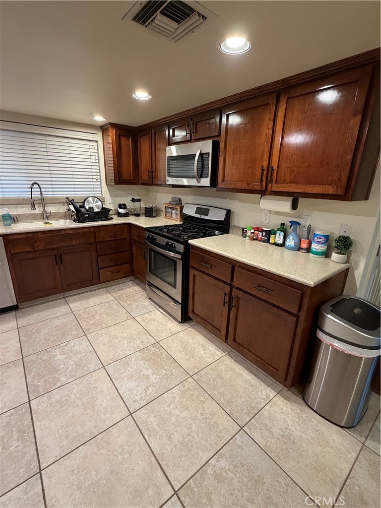 209 Kimberly Lane Ridgecrest, CA 93555 - Photo 18 of 62 a kitchen with stainless steel appliances granite countertop a stove a sink and a microwave