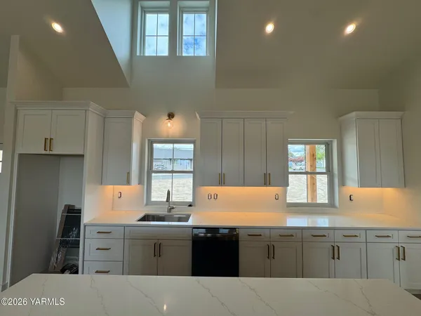 a kitchen with stainless steel appliances white cabinets and wooden floor
