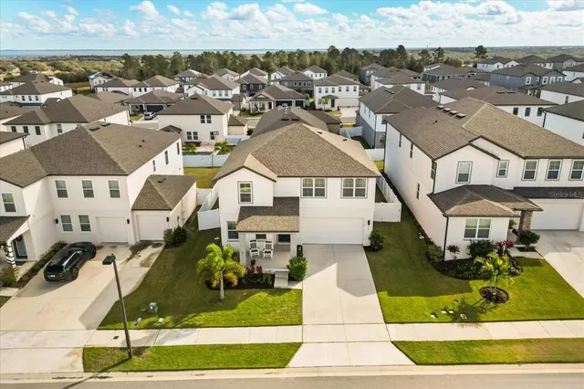 an aerial view of residential houses with outdoor space and parking