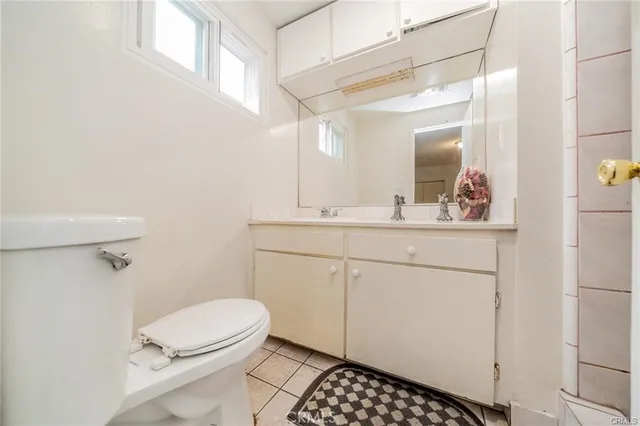 a spacious bathroom with a granite countertop sink a toilet and a mirror