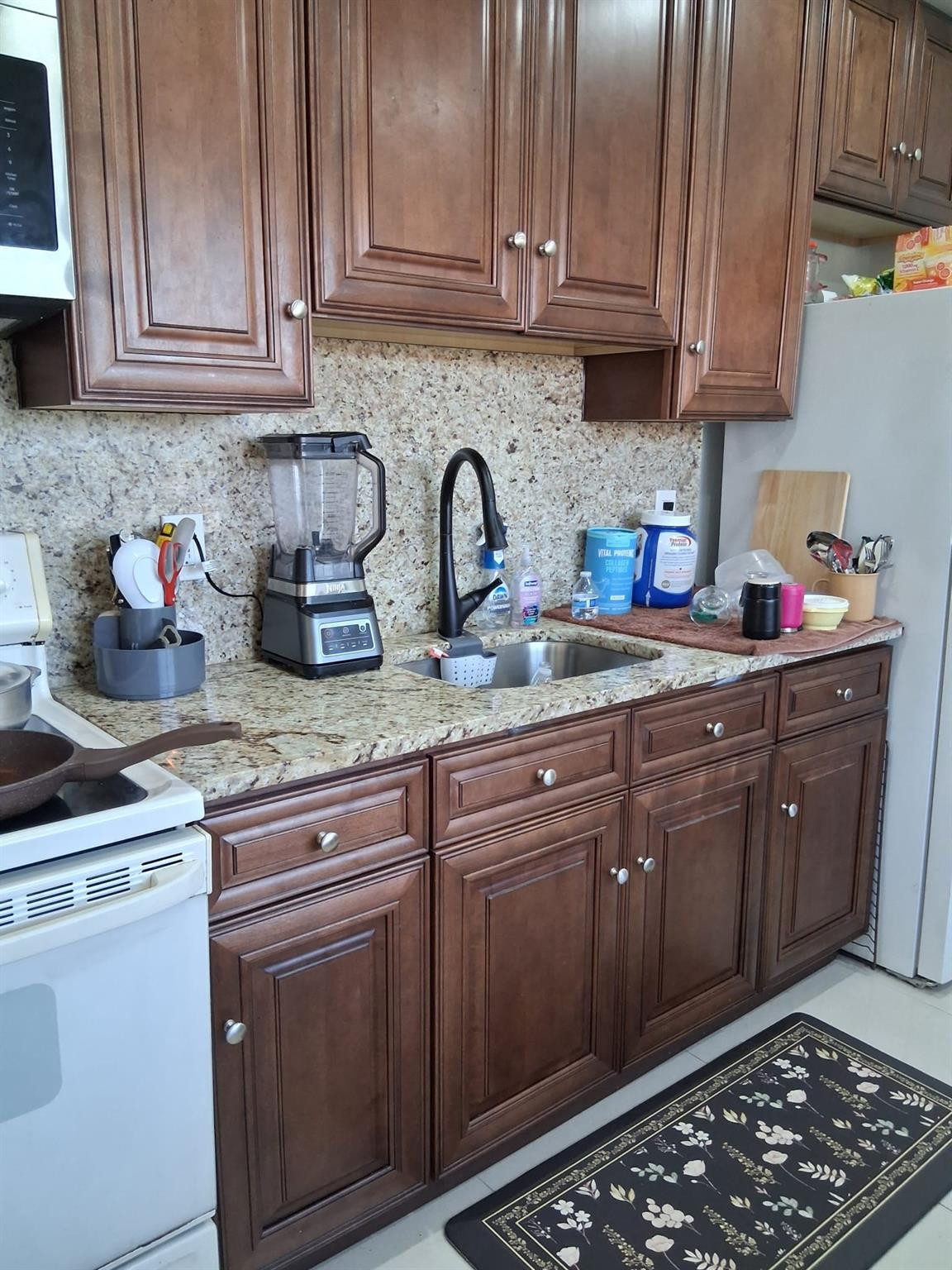 a kitchen with stainless steel appliances granite countertop a sink stove and cabinets