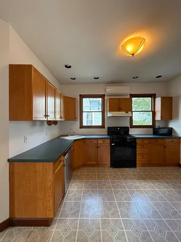 a large kitchen with a large counter top and stainless steel appliances