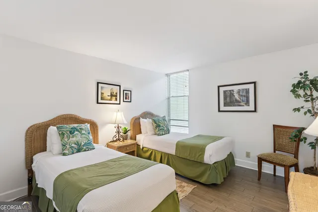 a bedroom with two beds and wooden floor
