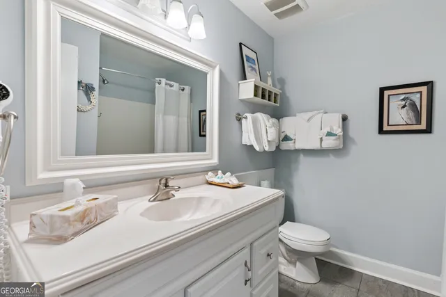 a bathroom with a sink vanity mirror and toilet