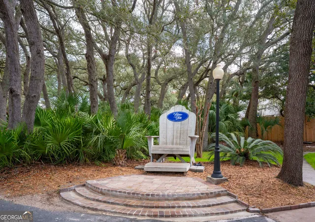 a sign board with a bench and trees