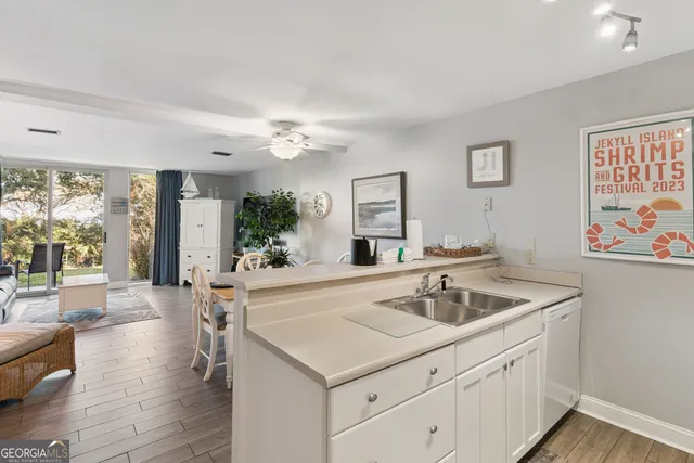 a spacious bathroom with a sink a large mirror and a wooden floor
