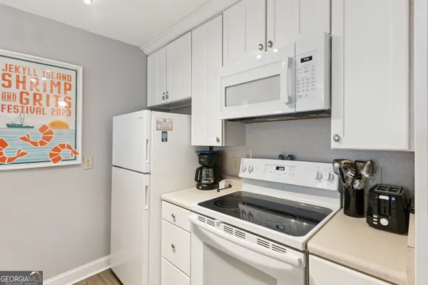 a kitchen with white cabinets and white appliances