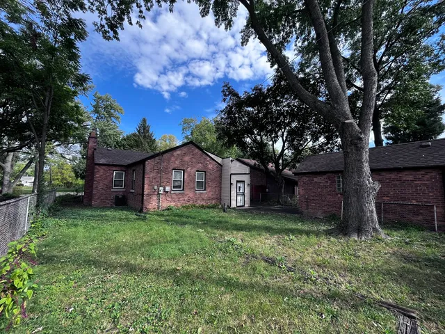 a view of a house with a big yard and large tree