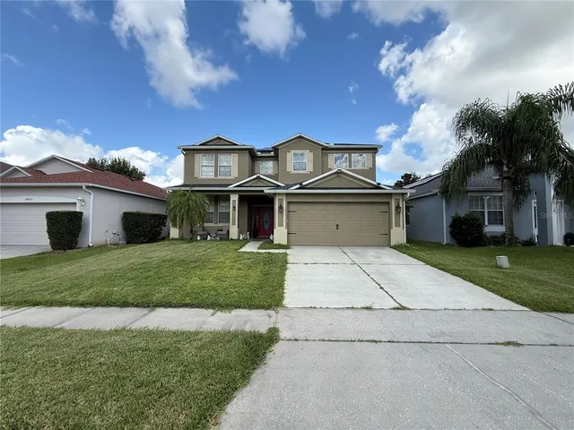 a front view of a house with a yard and garage