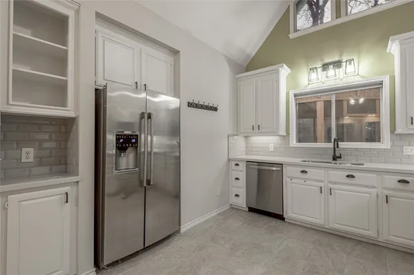 a spacious bathroom with a granite countertop sink mirror and stainless steel appliances
