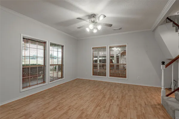 a view of an empty room with a window and wooden floor
