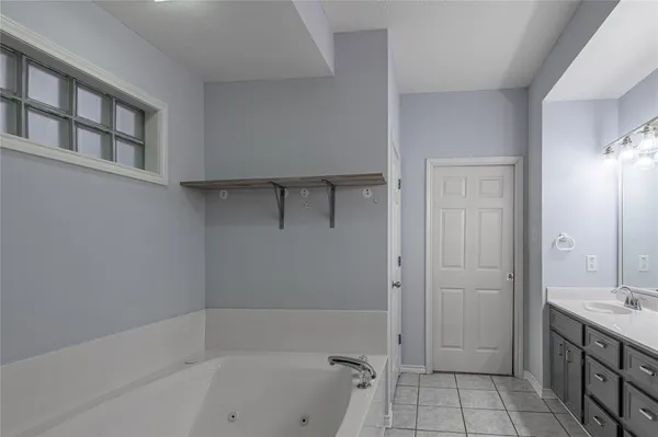 a bathroom with a tub shower vanity and a sink