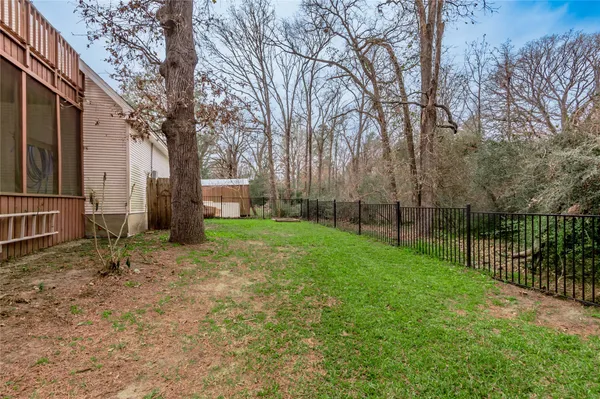 a view of a yard with plants and trees