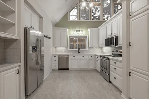 a kitchen with white cabinets and stainless steel appliances