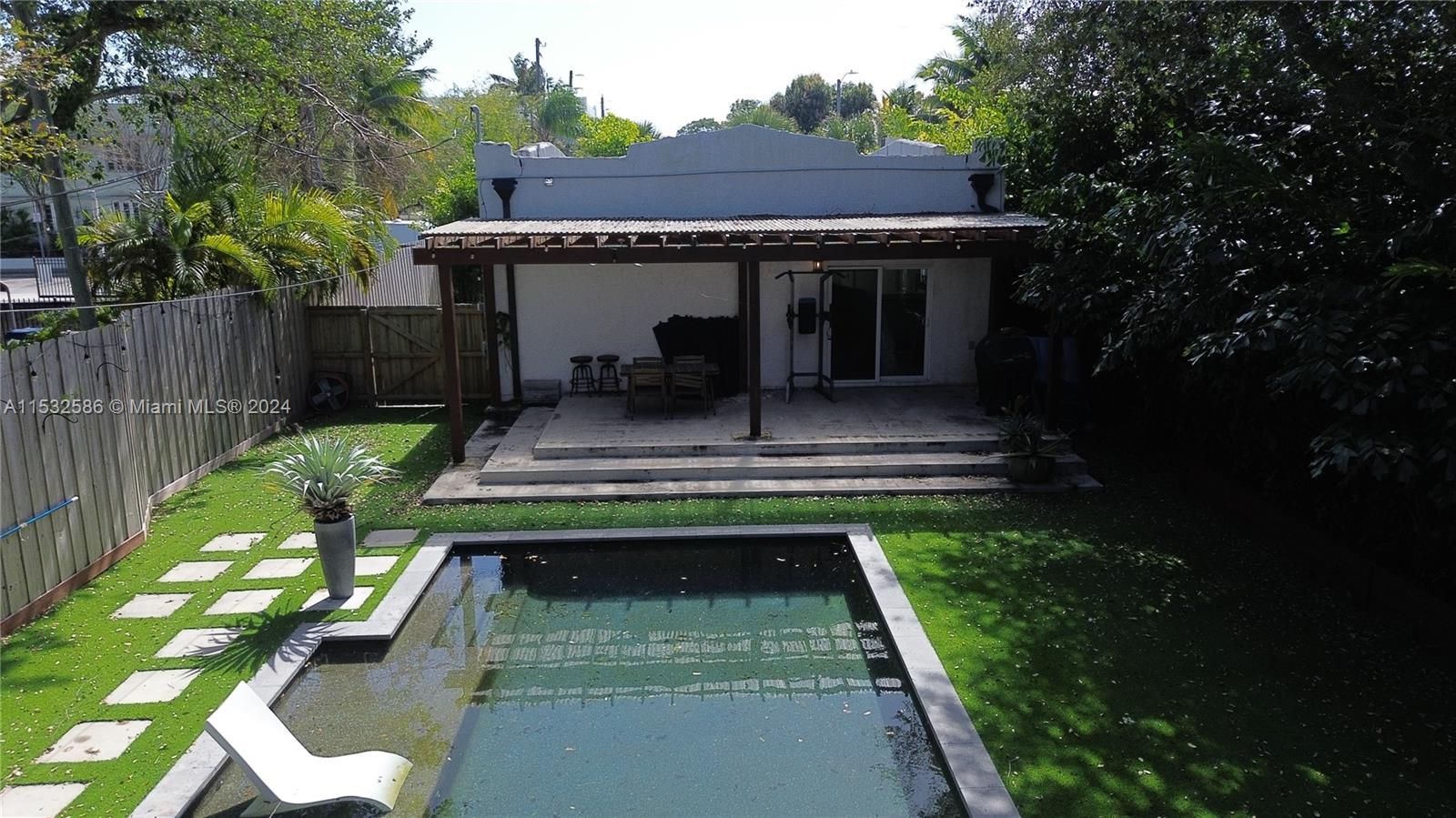 a view of house with backyard and sitting area