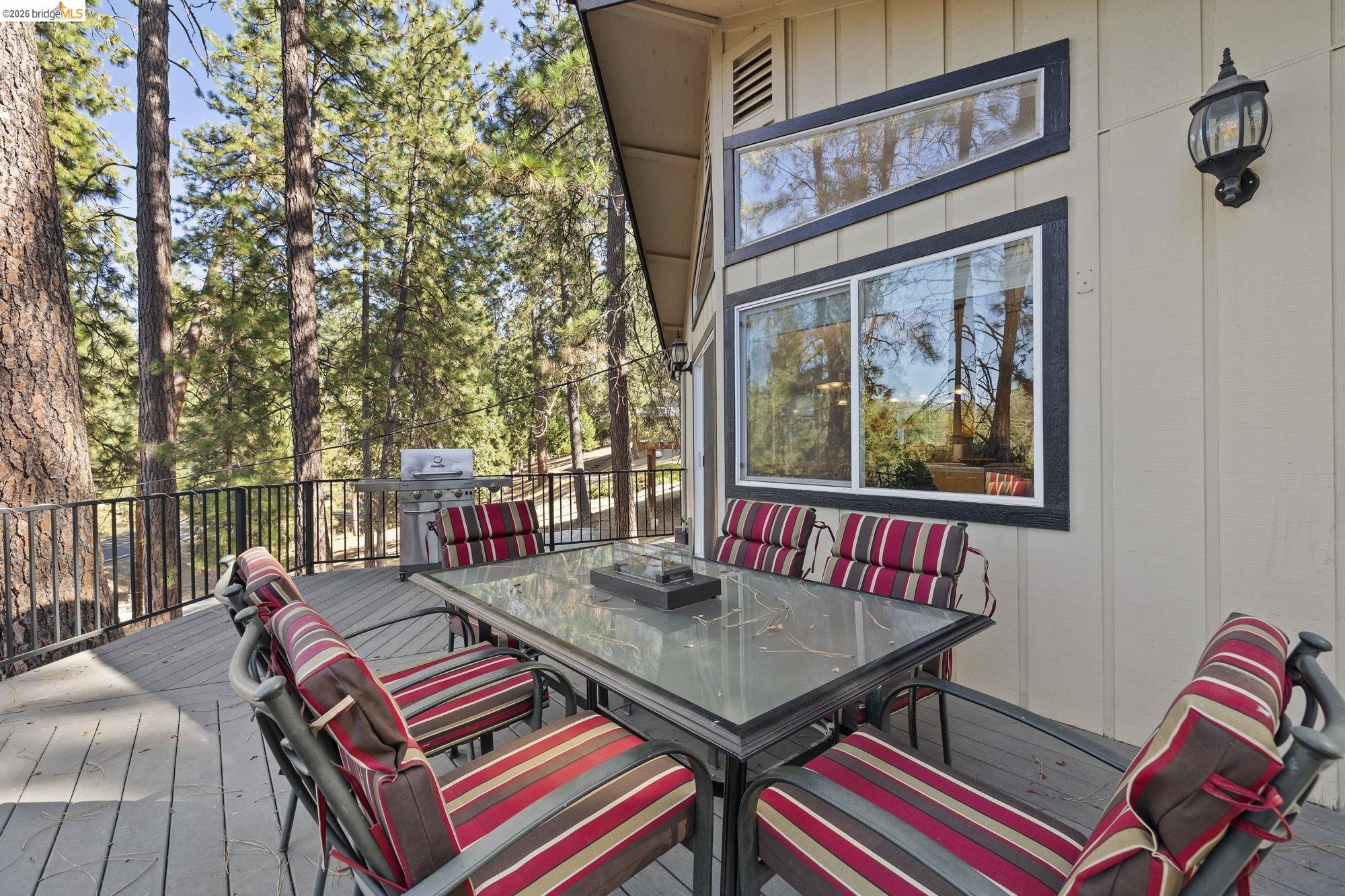 19369 Ferretti Road Groveland, CA 95321 - Photo 30 of 45 Wooden terrace featuring outdoor dining space, grilling area, and view of wooded area