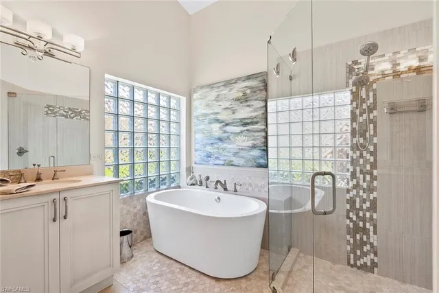 a bathroom with a granite countertop sink toilet a mirror a vanity and shower