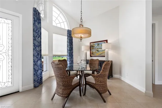 a dining room with furniture floor to ceiling window and potted plants