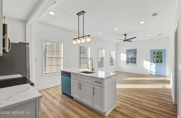 a kitchen with stainless steel appliances granite countertop a sink a stove and a refrigerator