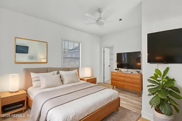 a bedroom with a bed a television and a couch
