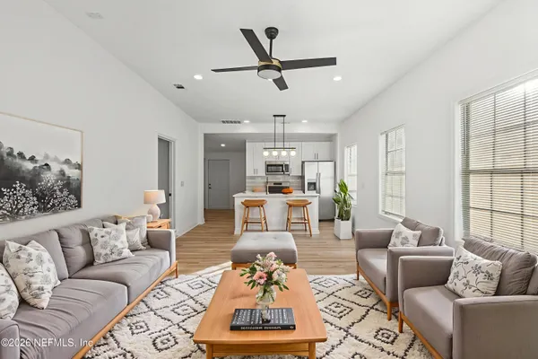 a living room with furniture ceiling fan and a window