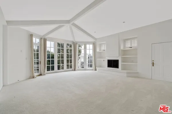 a view of an empty room with a fireplace and a window