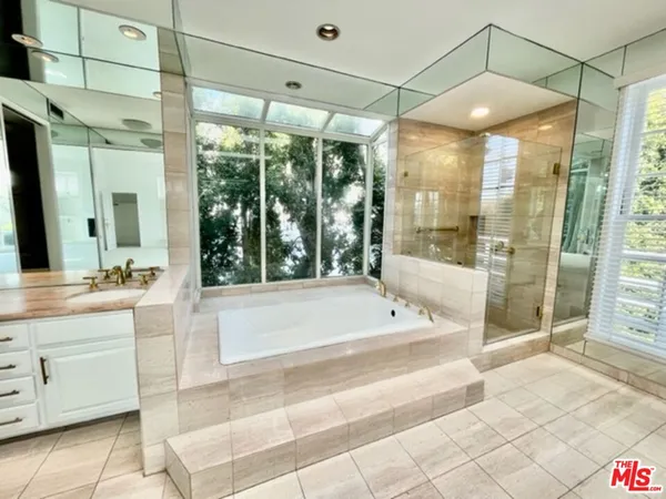 a spacious bathroom with a large tub shower and sink