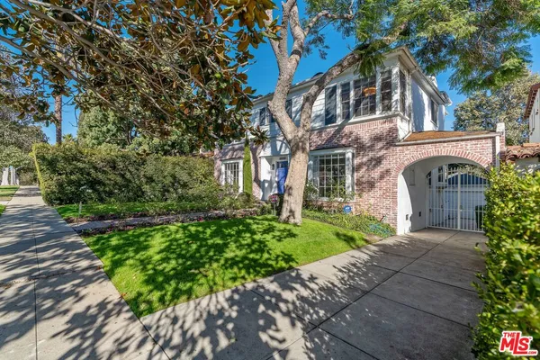 a front view of a house with a yard and potted plants