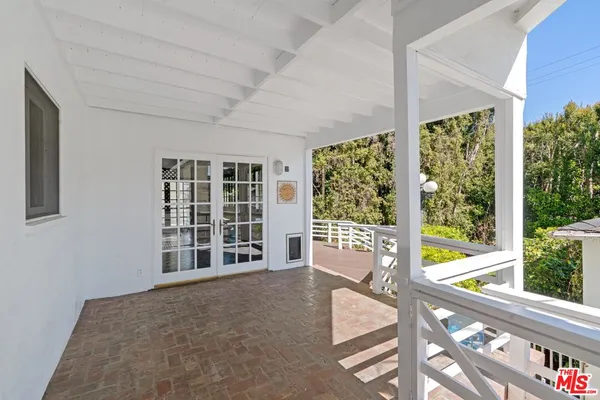 a view of an empty room with wooden floor and windows