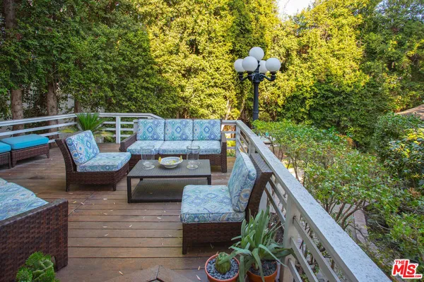 a balcony view with couple of couches and potted plants