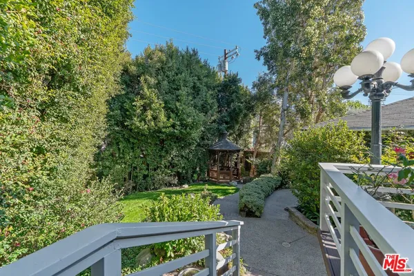 a view of a patio with couches table and chairs with wooden fence