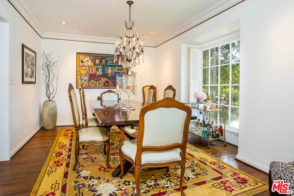 a view of a dining room with furniture a chandelier and wooden floor
