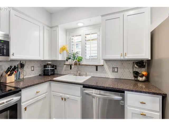 a kitchen with stainless steel appliances granite countertop a sink a stove cabinets and counter space