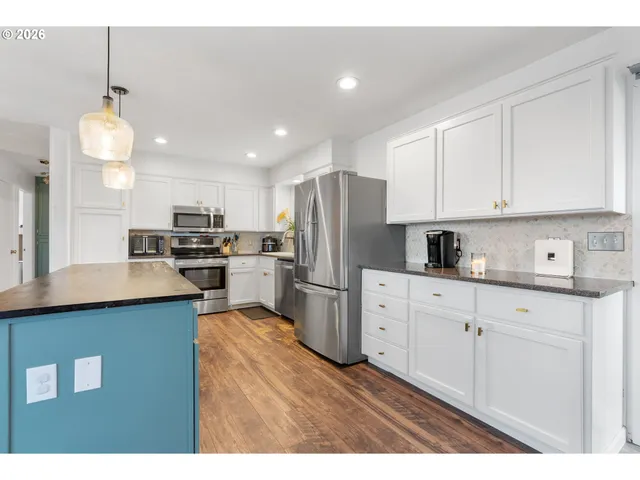 a kitchen with refrigerator cabinets and wooden floor