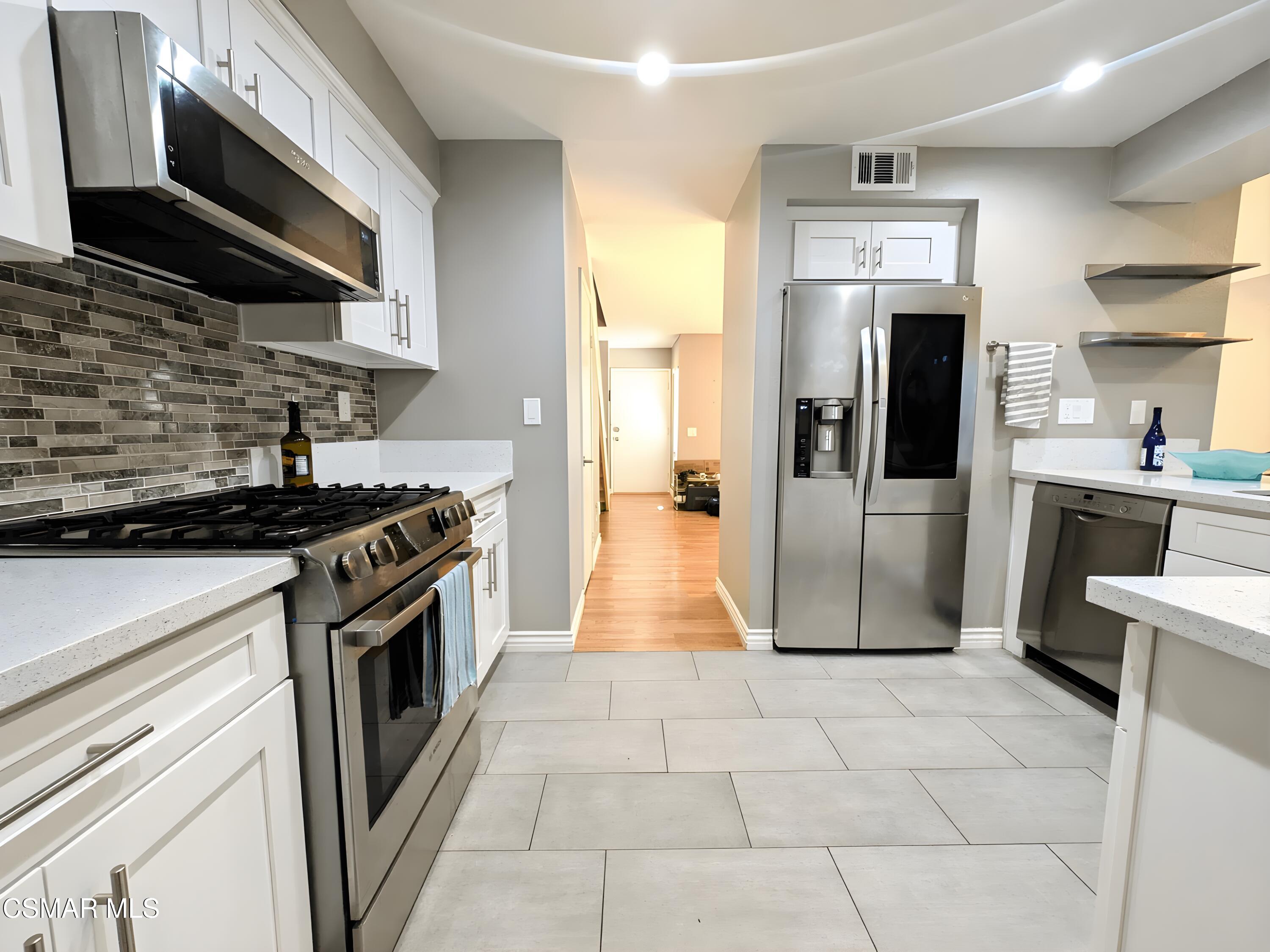 28713 Conejo View Drive Agoura Hills, CA 91301 - Photo 9 of 28 a kitchen with stainless steel appliances granite countertop a stove a refrigerator and a microwave