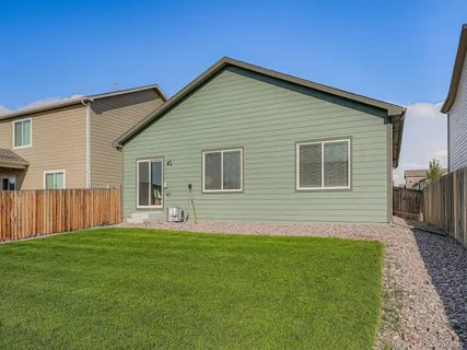 a front view of house with yard and trees in the background