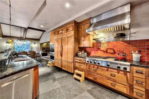 a kitchen with stainless steel appliances granite countertop a sink and a refrigerator