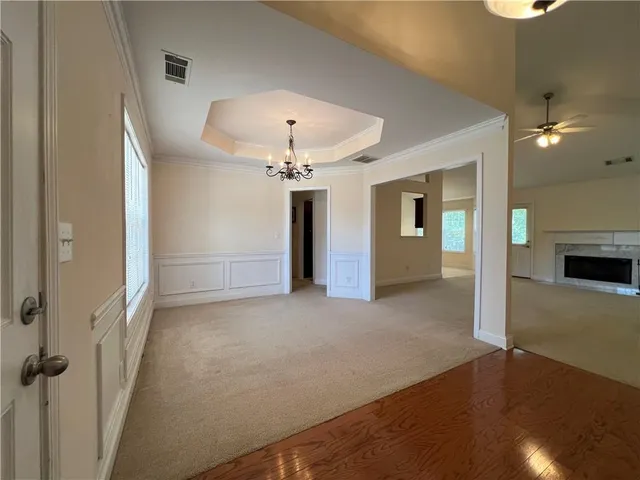 an empty room with windows and fireplace
