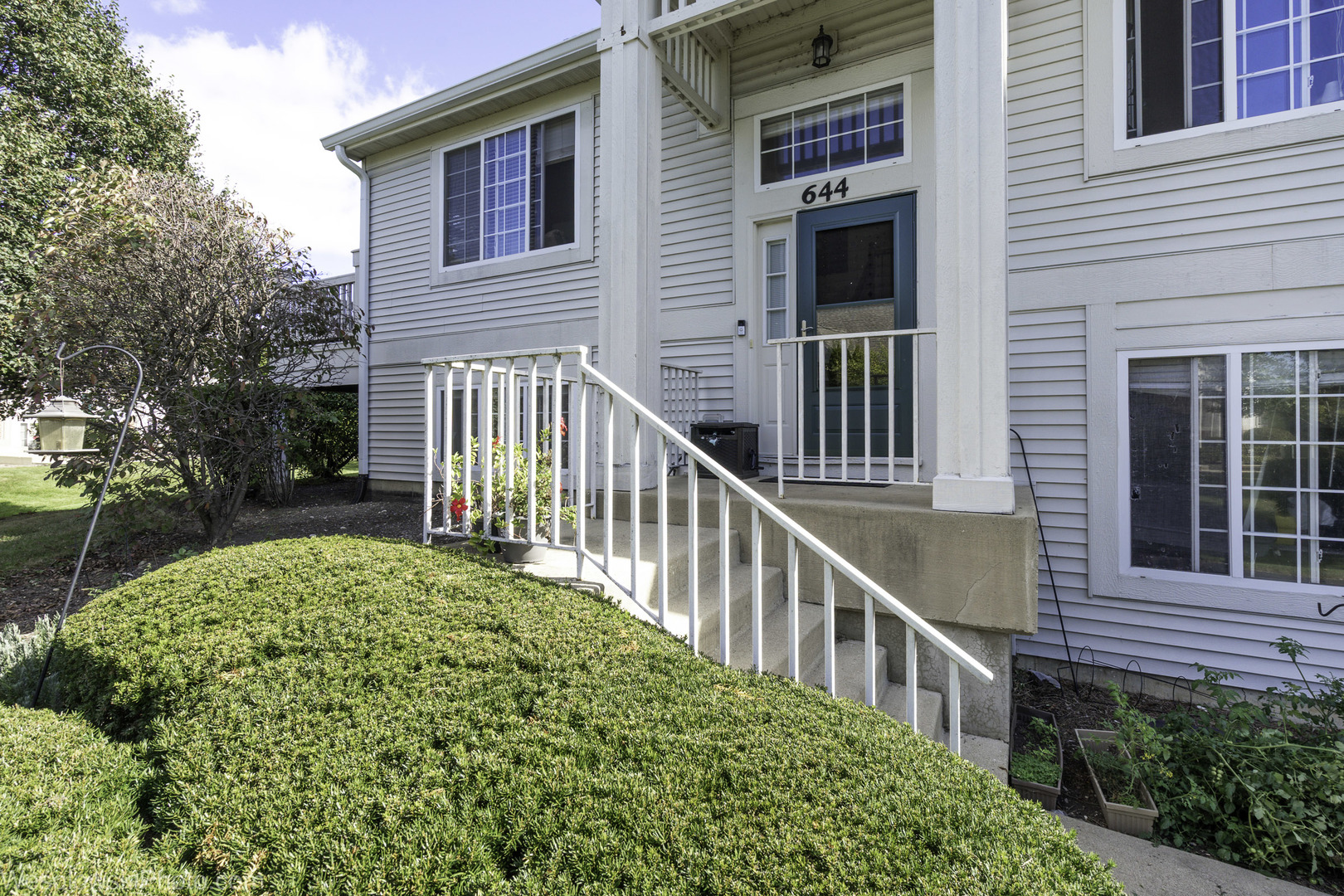 644 South Rosehall Lane, Unit 644 Round Lake, IL 60073 - Photo 1 of 33 a view of a house with brick walls and a flower plants