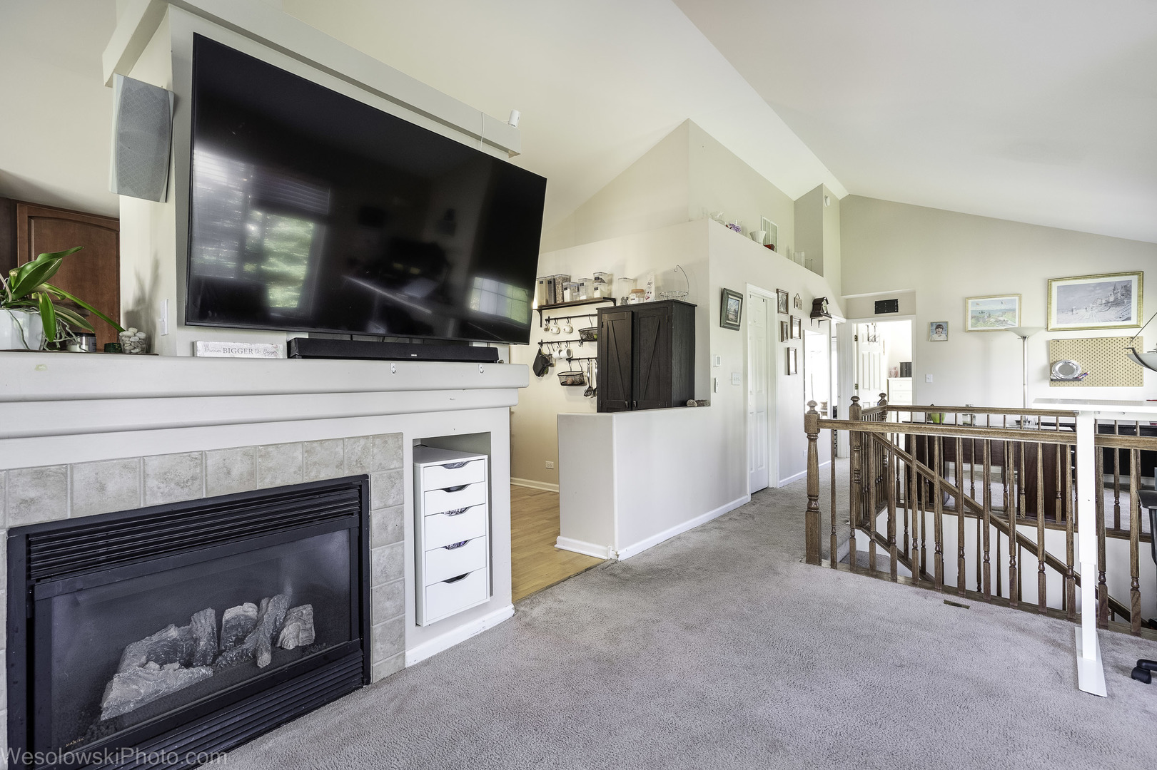 644 South Rosehall Lane, Unit 644 Round Lake, IL 60073 - Photo 3 of 33 a living room with a fireplace a flat screen tv and a view of kitchen