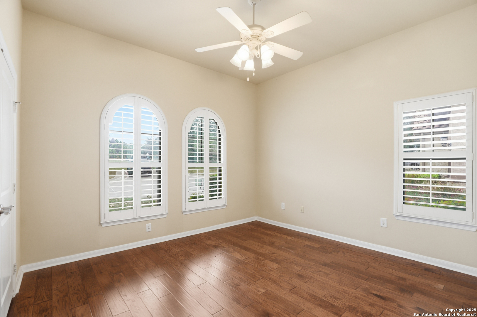 7800 Sw Parkway, Unit 1710 Austin, TX 78735 - Photo 16 of 34 an empty room with wooden floor chandelier fan and windows