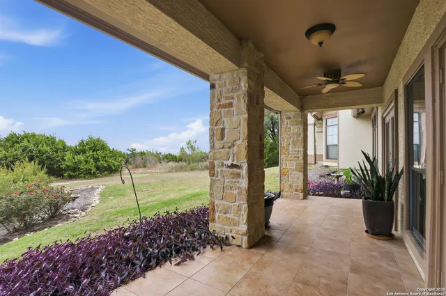 a porch with a table and chairs next to yard