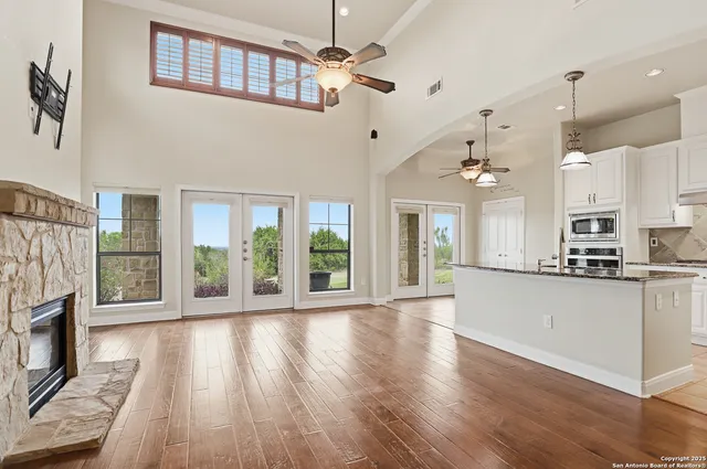 a large kitchen with stainless steel appliances granite countertop a stove top oven a refrigerator a sink and wooden floor